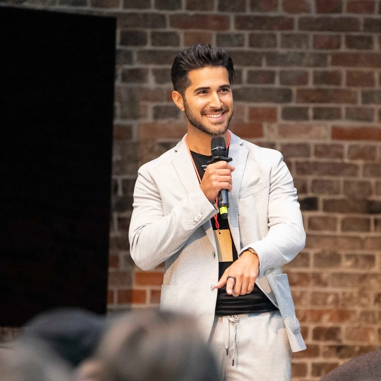 Shahin Farahzadi – KI-Keynote-Speaker auf der Bühne mit Mikrofon